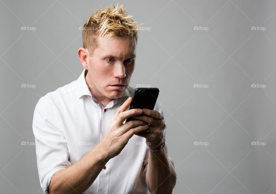 Man with cellular phone acting surprised.