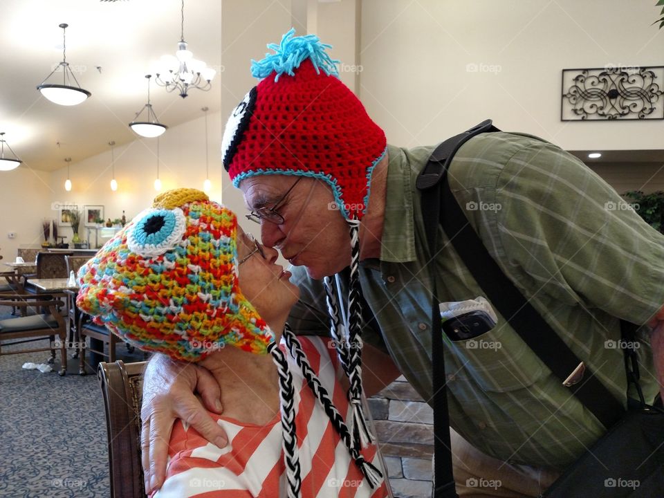 Love Senior Married Couple Kissing in Funny hats at Birthday