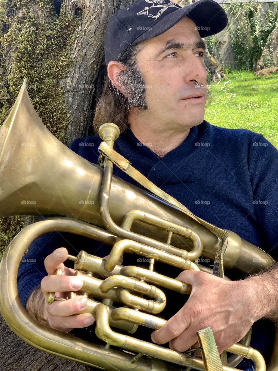 Portrait of Ricardo under a tree, taking a break from tuba practice