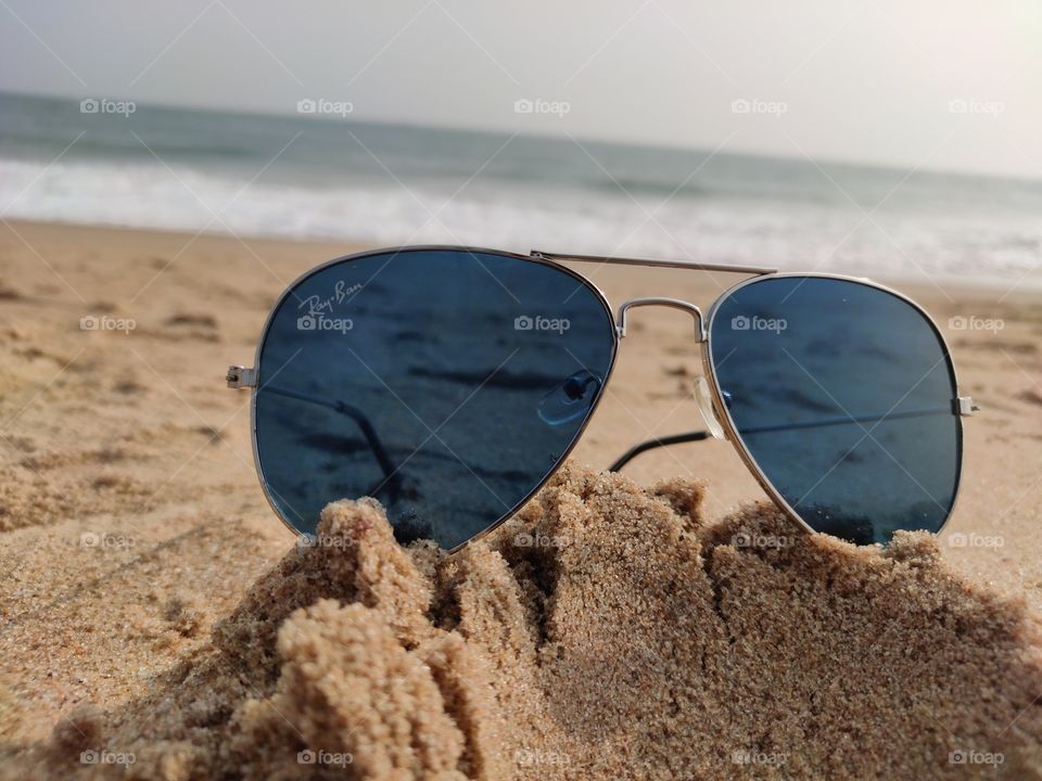 dark shade sun glass laying at chandrabhaga sea beach sand.