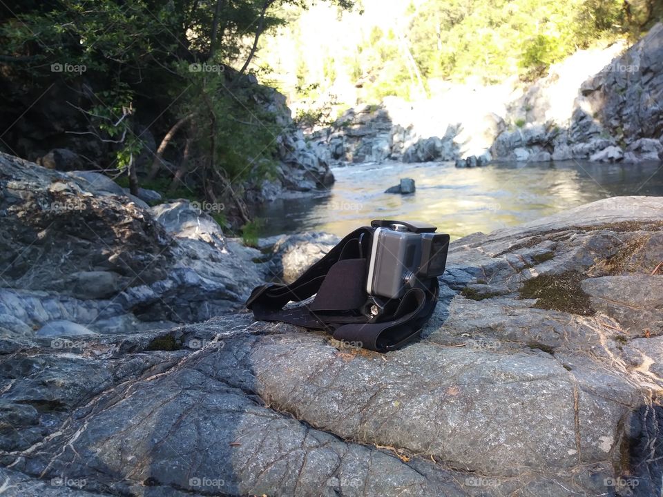 action camera on strap by river
