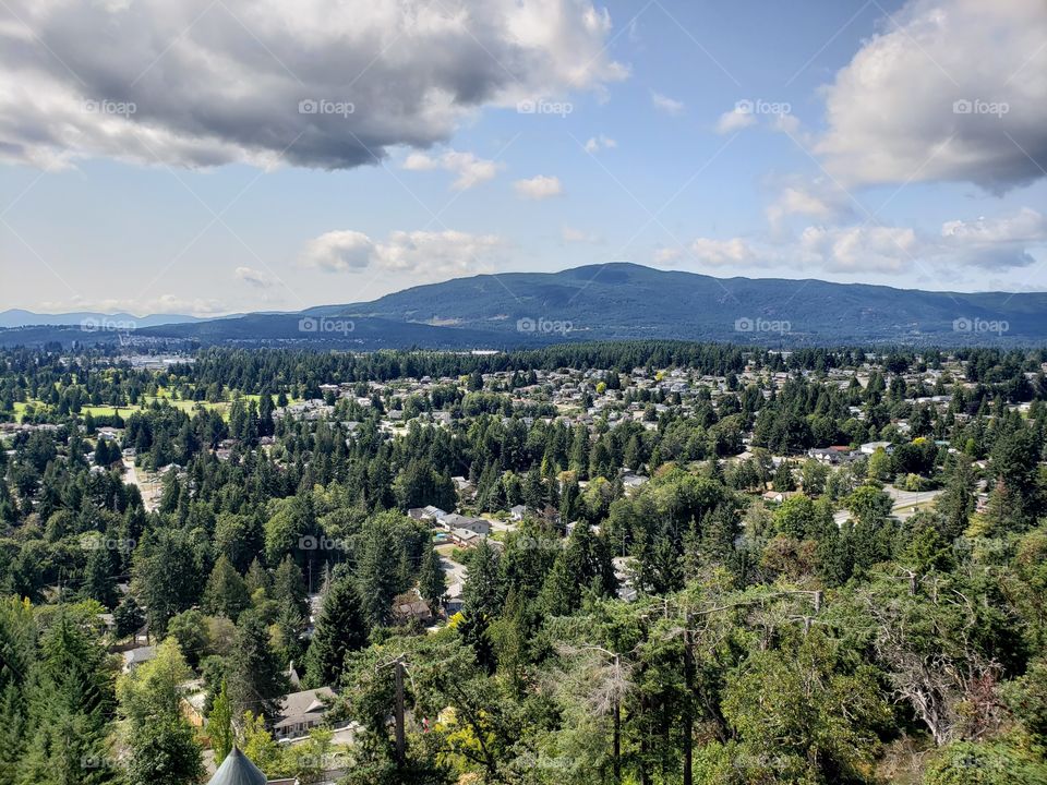 View from above, city of Nanaimo, Vancouver Island, British Columbia, Canada. Houses, hills, trees, with blue cloudy sky.