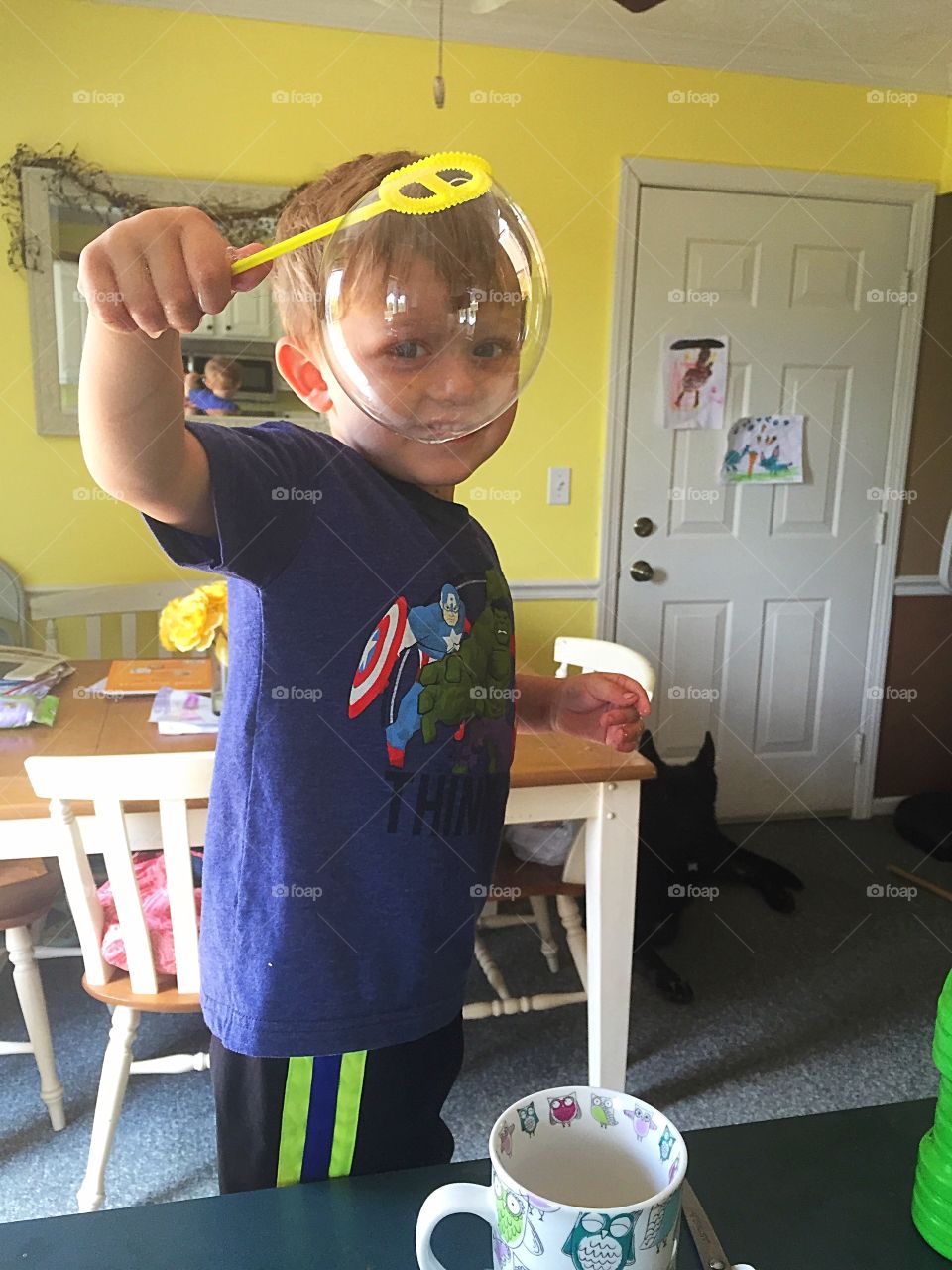 Small boy playing with bubble at home