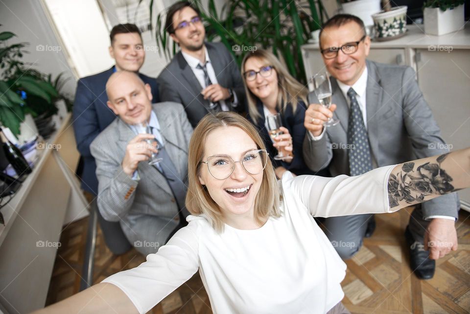 Happy business team with champagne glasses taking selfie at business meeting