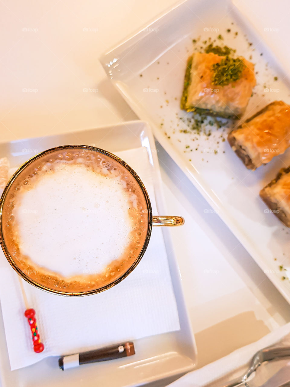 Top view of turkish dessert baklava with pistachio on the plate and cup of coffee.