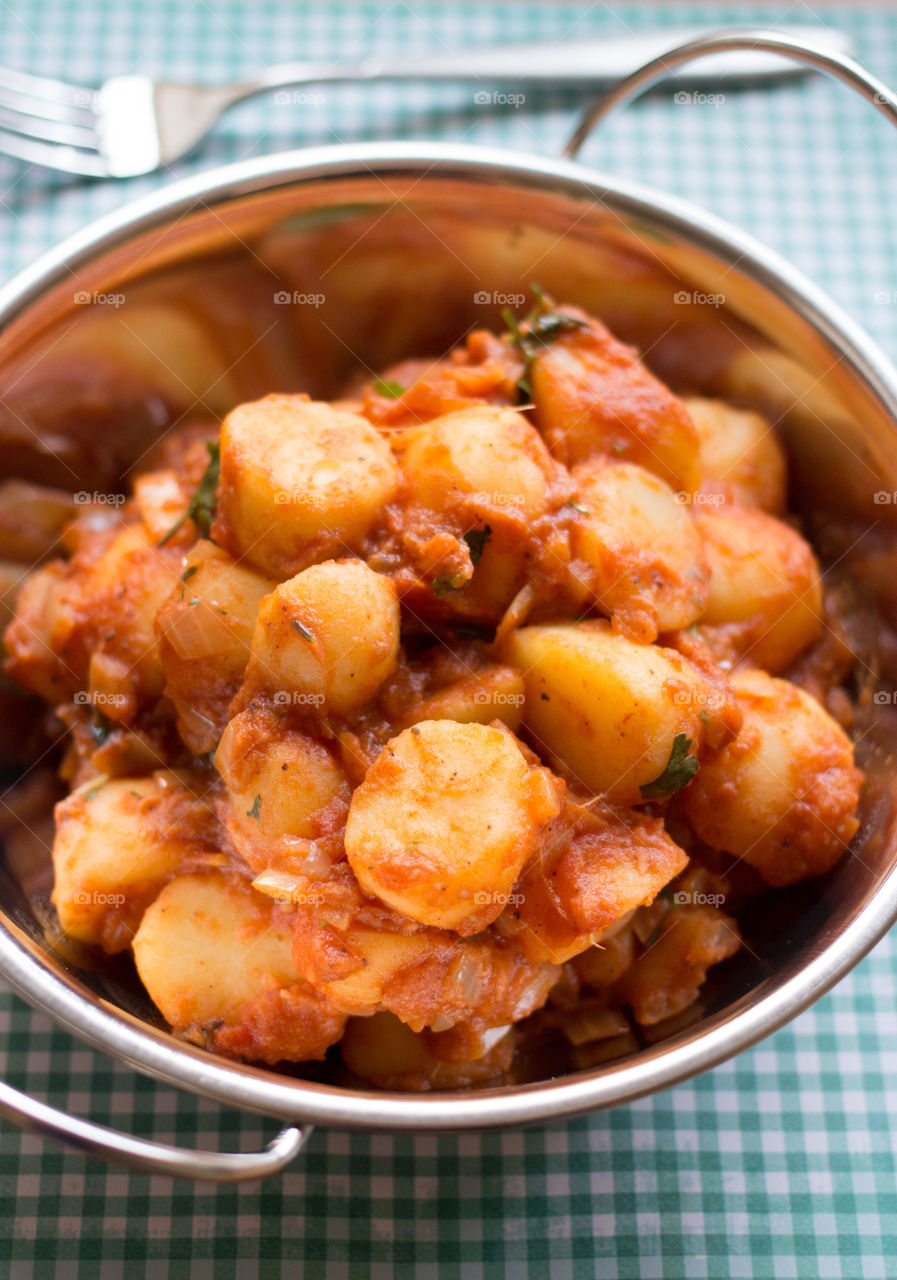 Bombay potato in silver dish. Bombay potato in traditional Indian balti dish