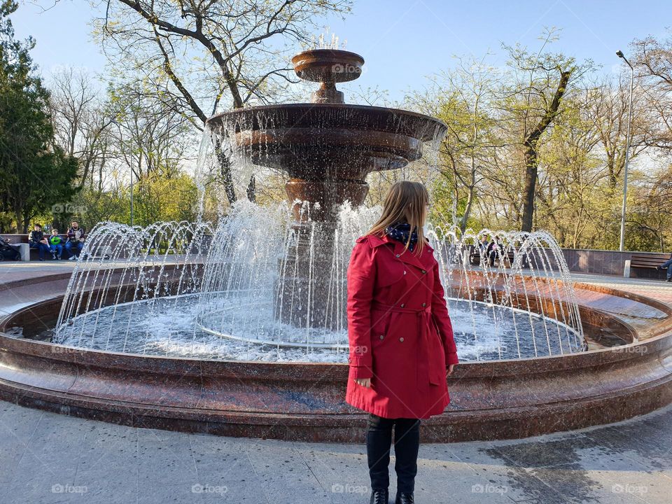 Circle fountain and woman in red trench 