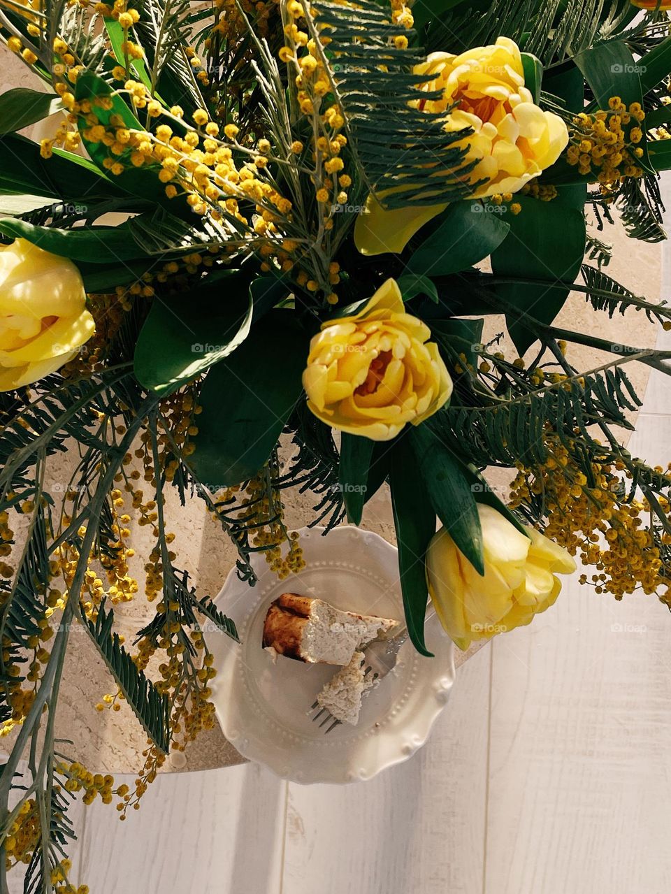 Bouquet of yellow spring flowers and home made cheesecake 