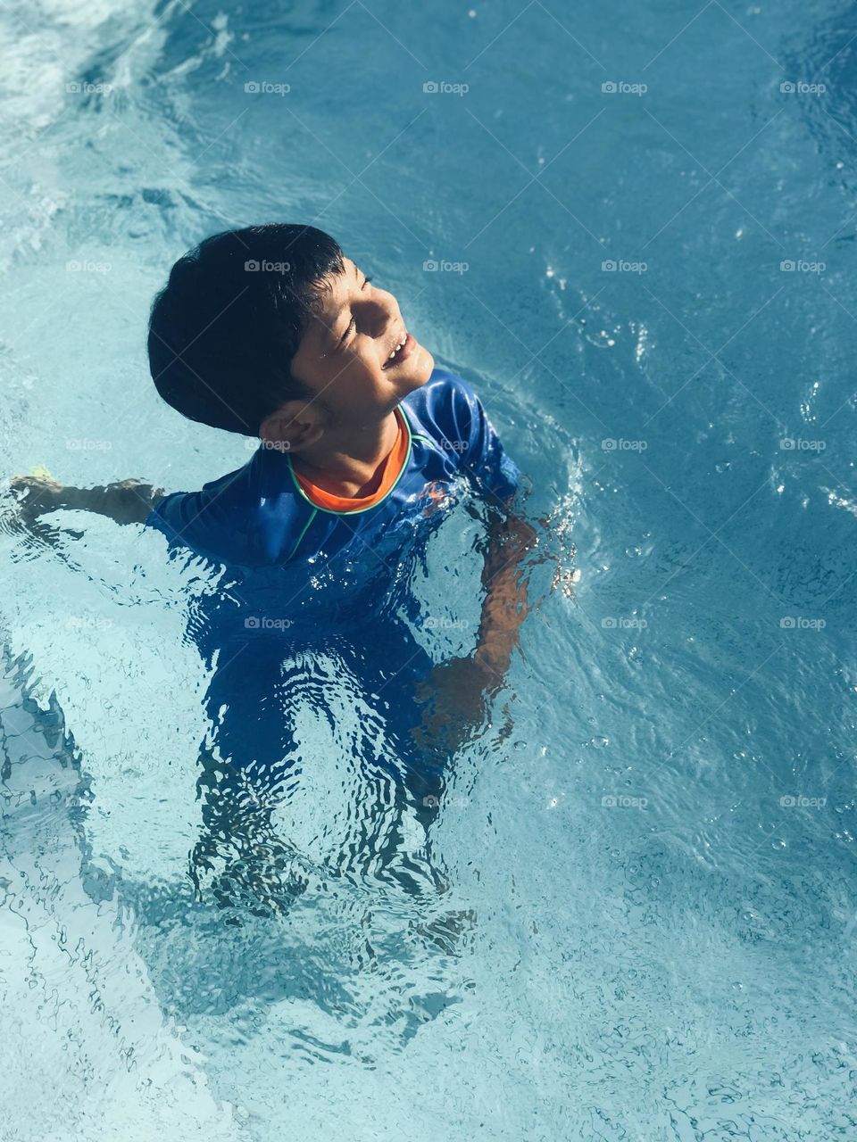 A boy in pool feels warm from the sun ☀️