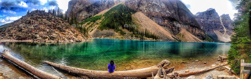 Distant view of person sitting near lake