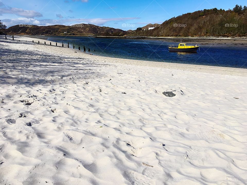White beach, yellow boat in the highlands