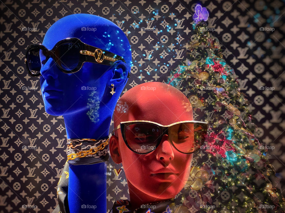 Christmas shopping - an upscale shop window display with reflections of a Christmas tree and holiday lights