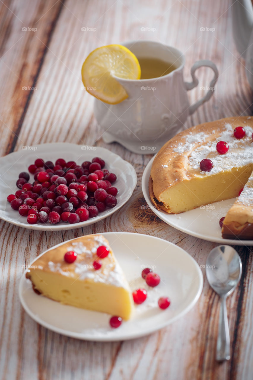 Cheesecake with cranberries and sugar on wooden background 