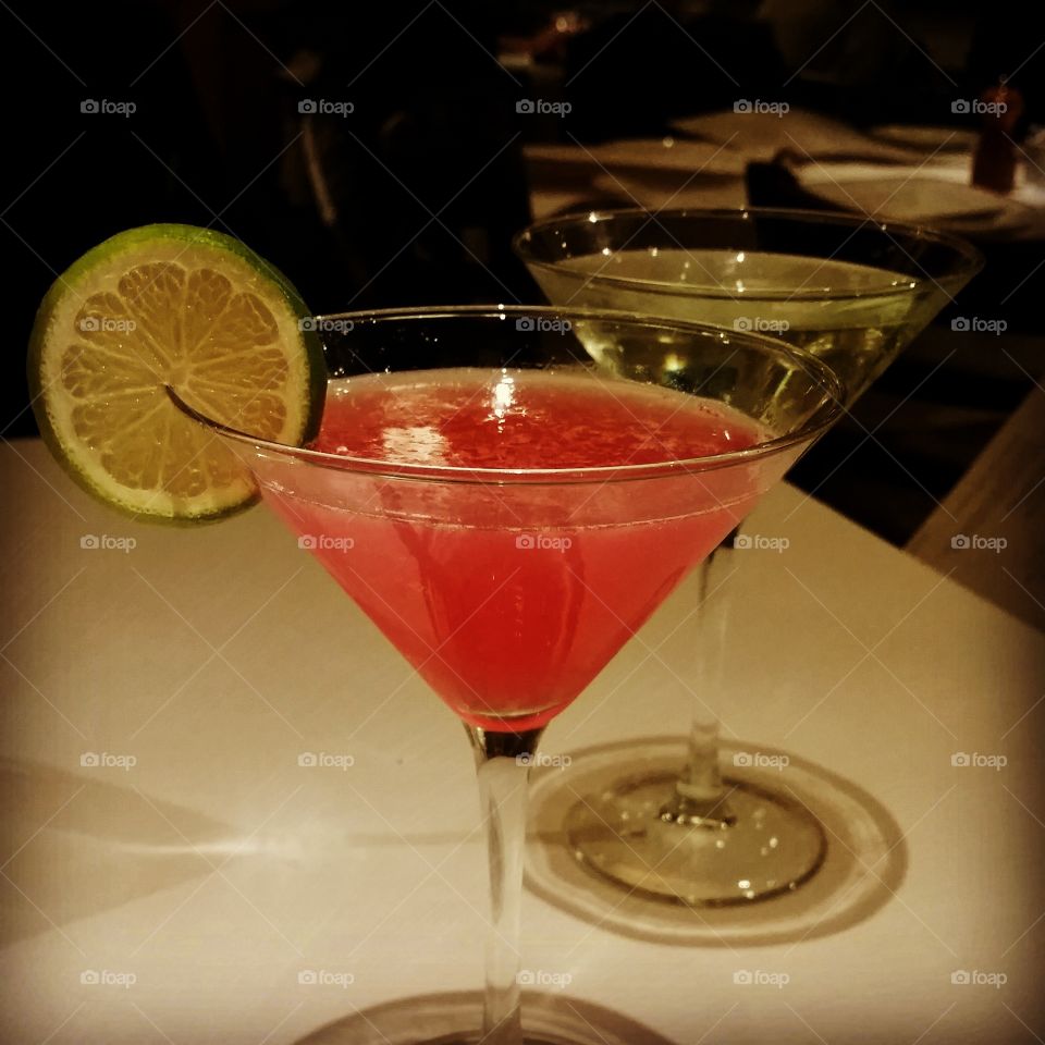Pink drink in martini glass with lime slice