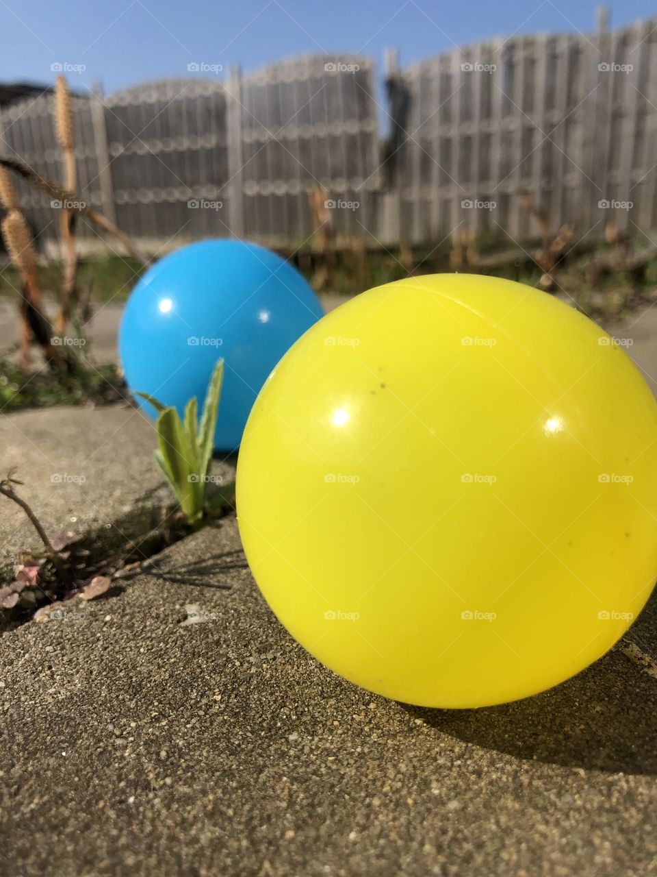 While playing with my little ones outside this two balls were thrown together and that’s how I got the idea to take this photo. The yard is a bit messy like war usually is. The balls really stand out.