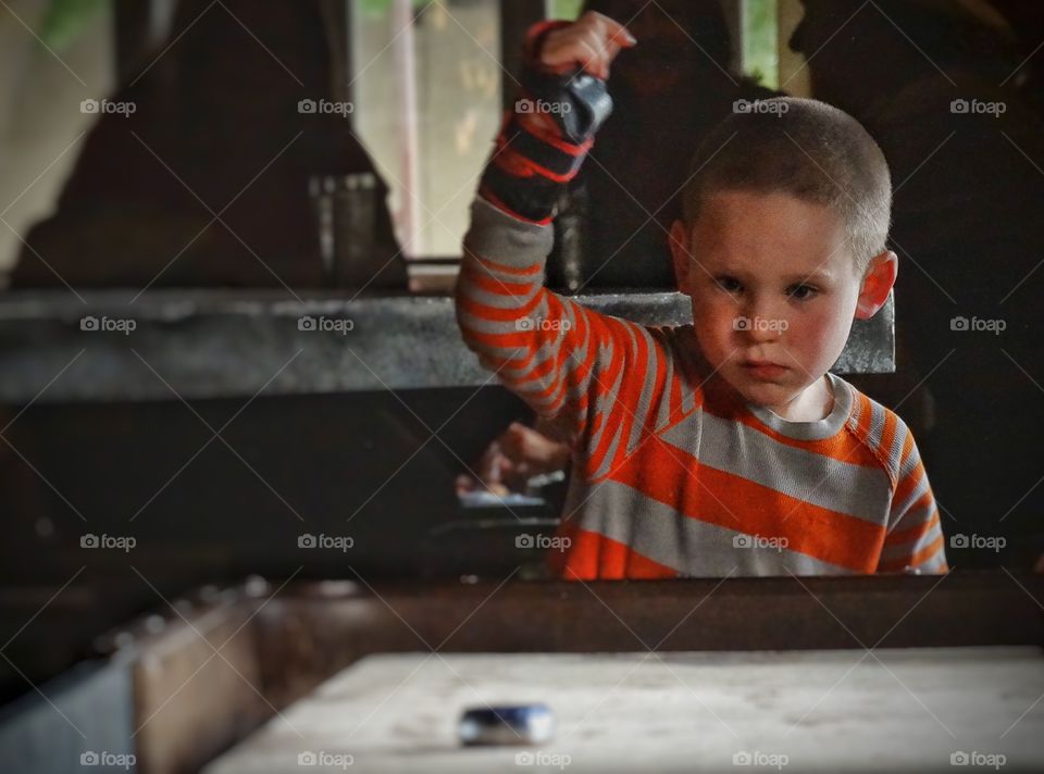 Boy Playing Shuffleboard. Young Boy Playing Indoor Shuffleboard
