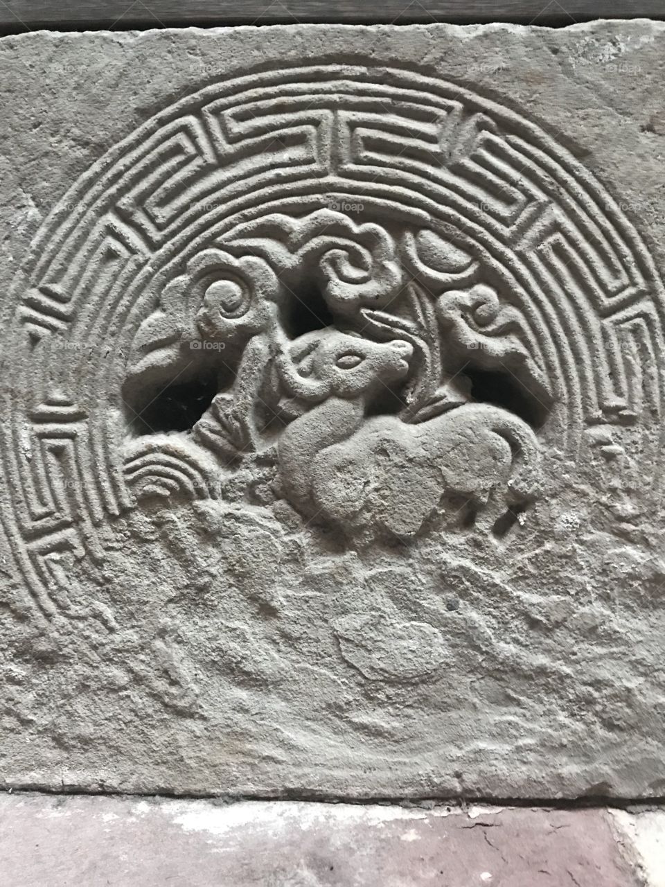 An old Chinese stone carving of the ram, worn away over time