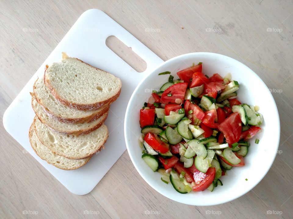 Top down of summer salad with bread.