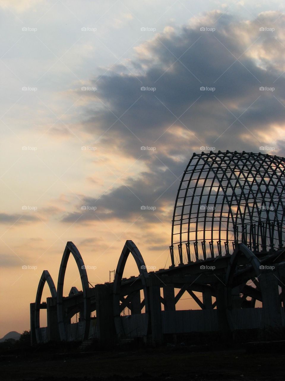 Portrait of a large unfinished building structure with a beautiful twilight sky in the background