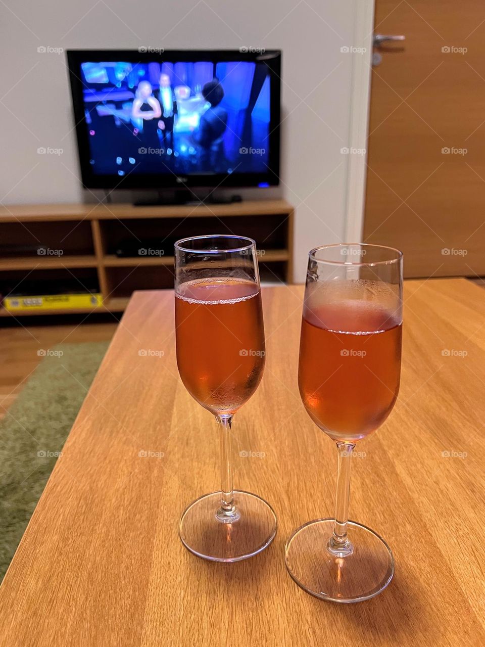 Watching awarded tv-show with two glasses of champagne 