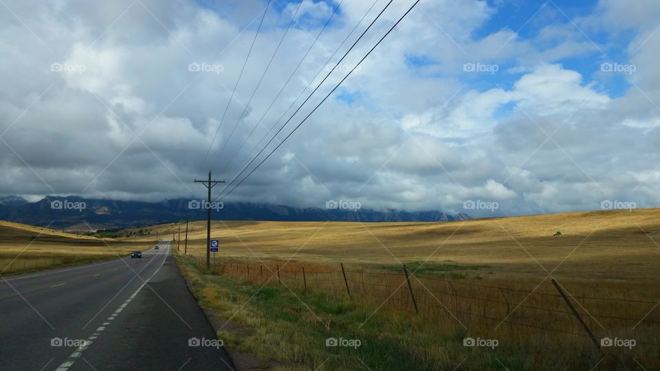 A long mountain country road under a cloudy sky.