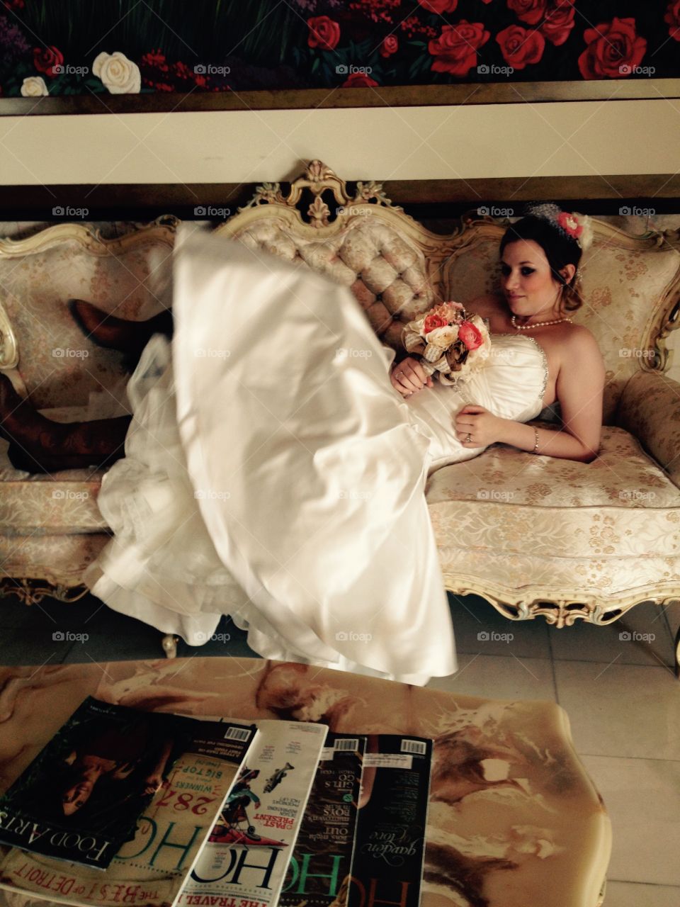 Bride lying on sofa with flowers