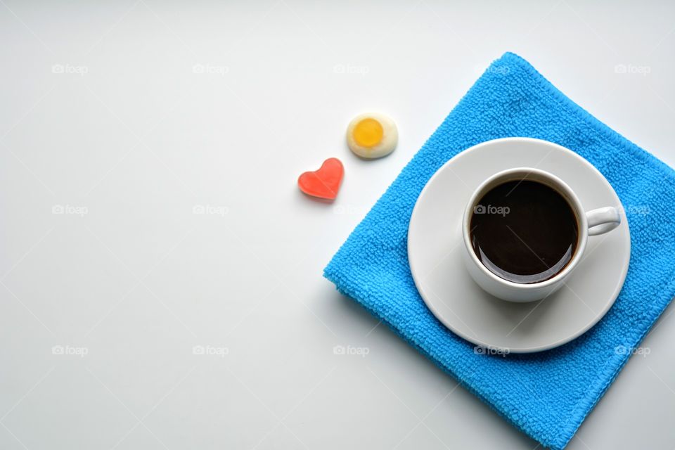 cup of coffee with candy symbolism top view white background