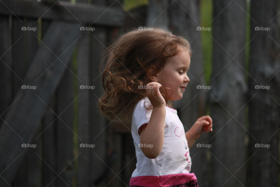 Cute girl playing near fence