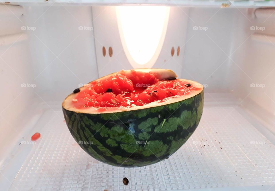 A half cut watermelon in the fridge, a must for hot summer day