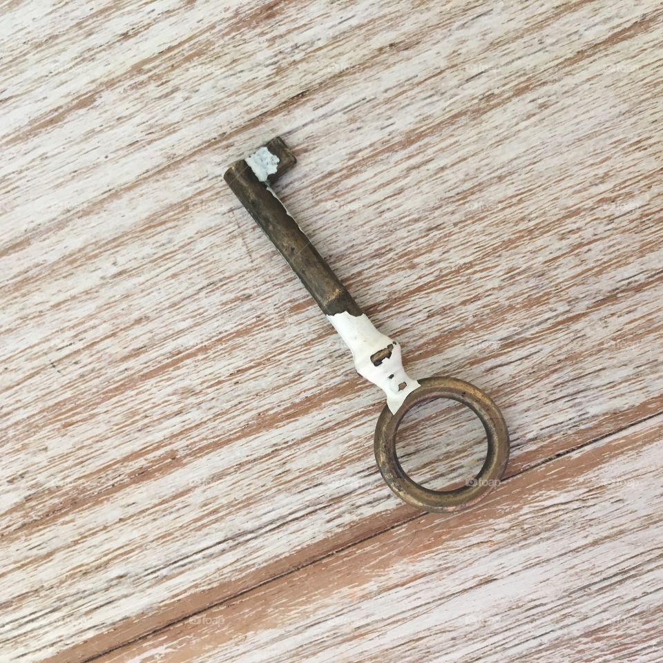 Old metal key on wooden table