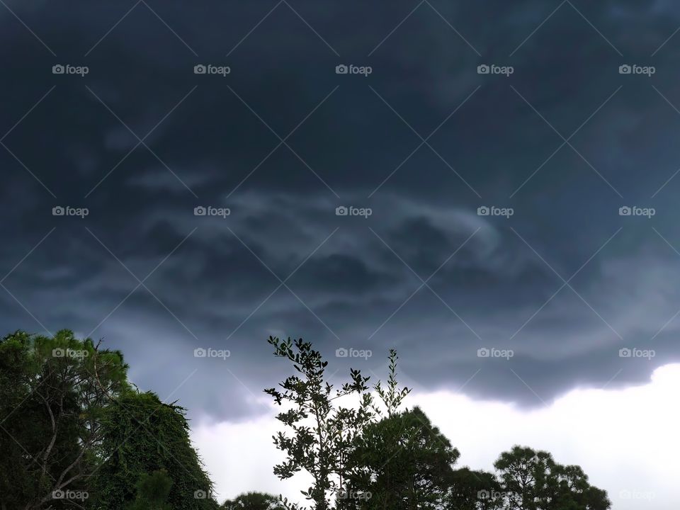 Dark and ominous clouds forming into a storm.