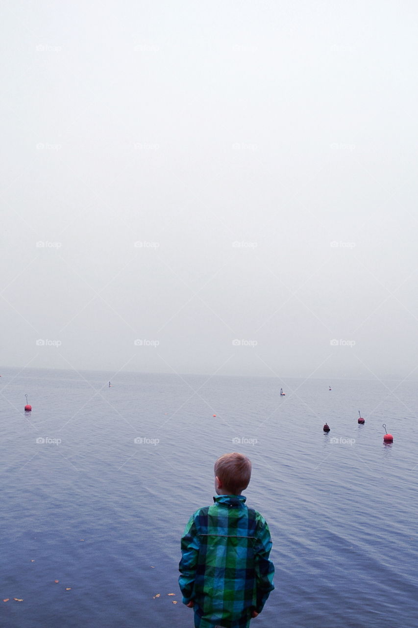 Boy at the lake a cold morning