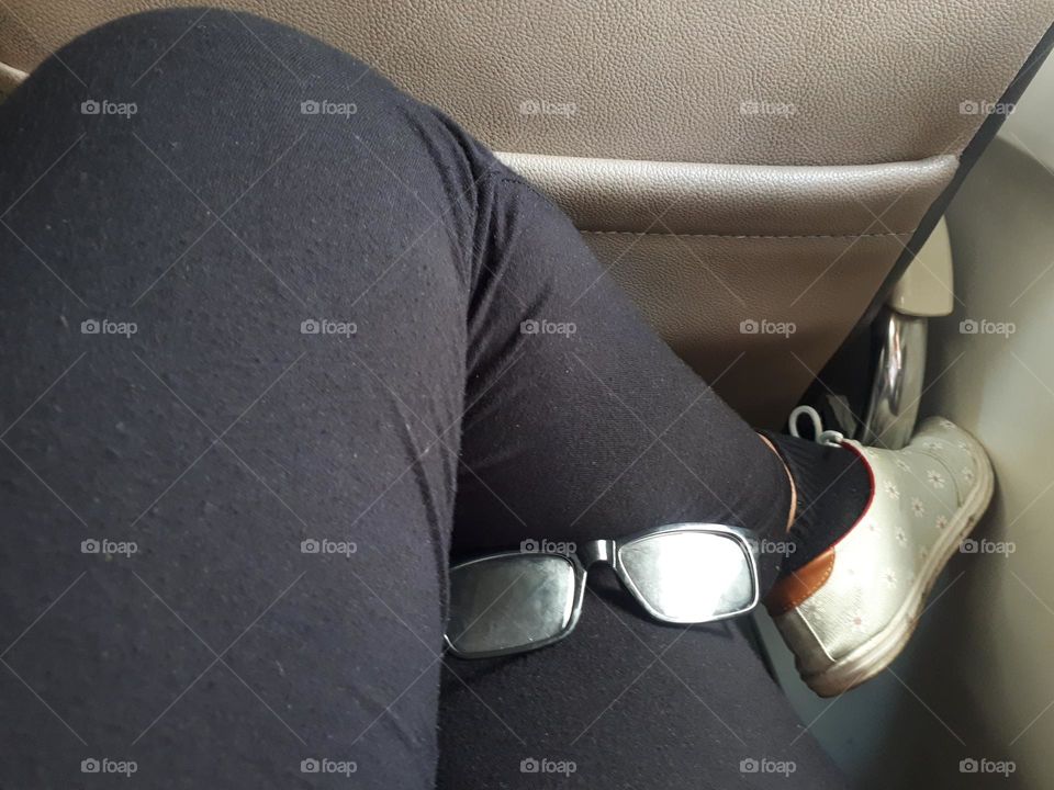 glasses as a cute accessory when placed on a woman's thigh while sitting on a train