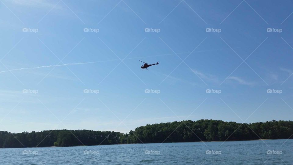 helicopter flying over lake