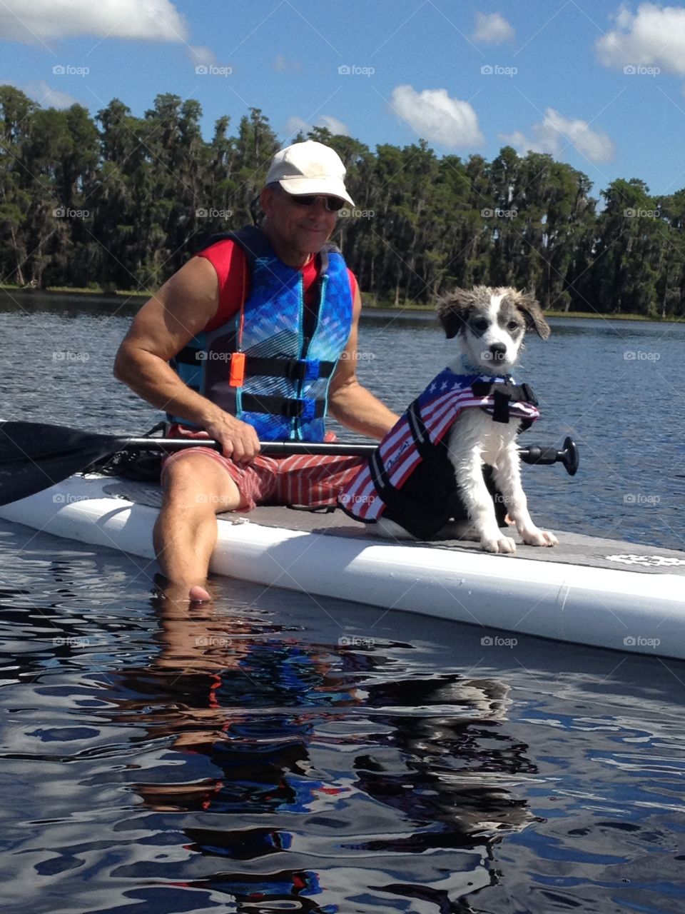 Man kayaking with dog in river