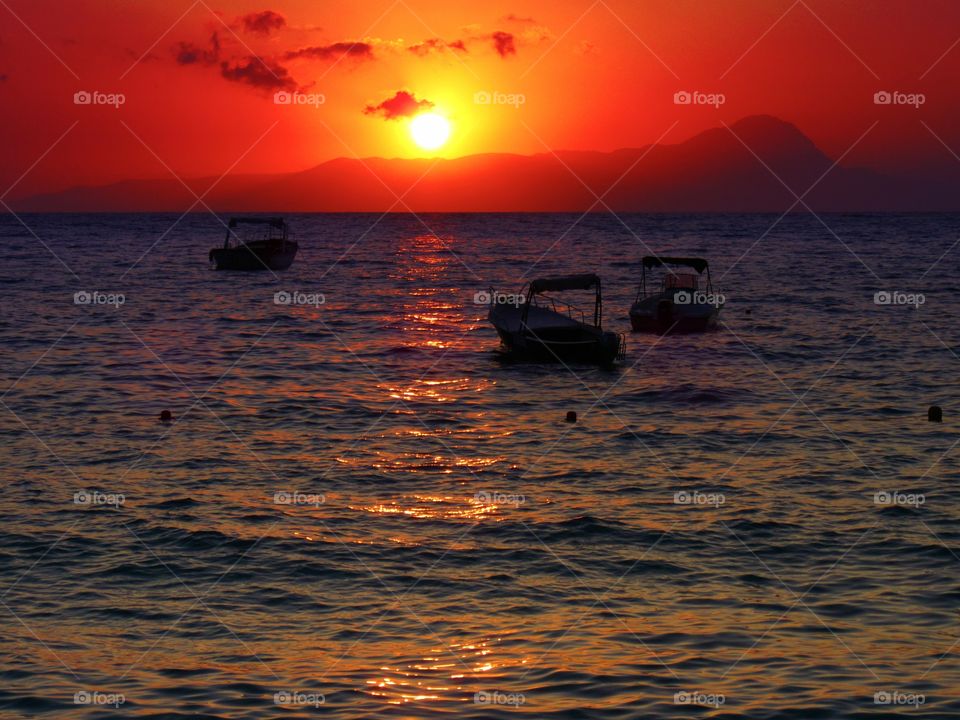 The sun goes down behind mountain and wake of sunlight. (Praia - Italy ).