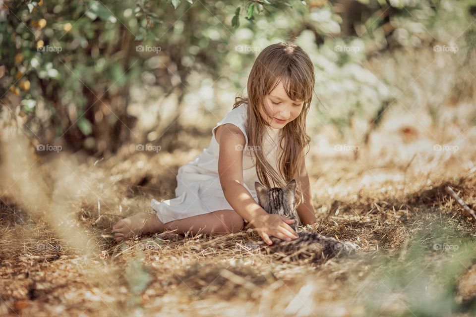 Children playing with kitten in a garden