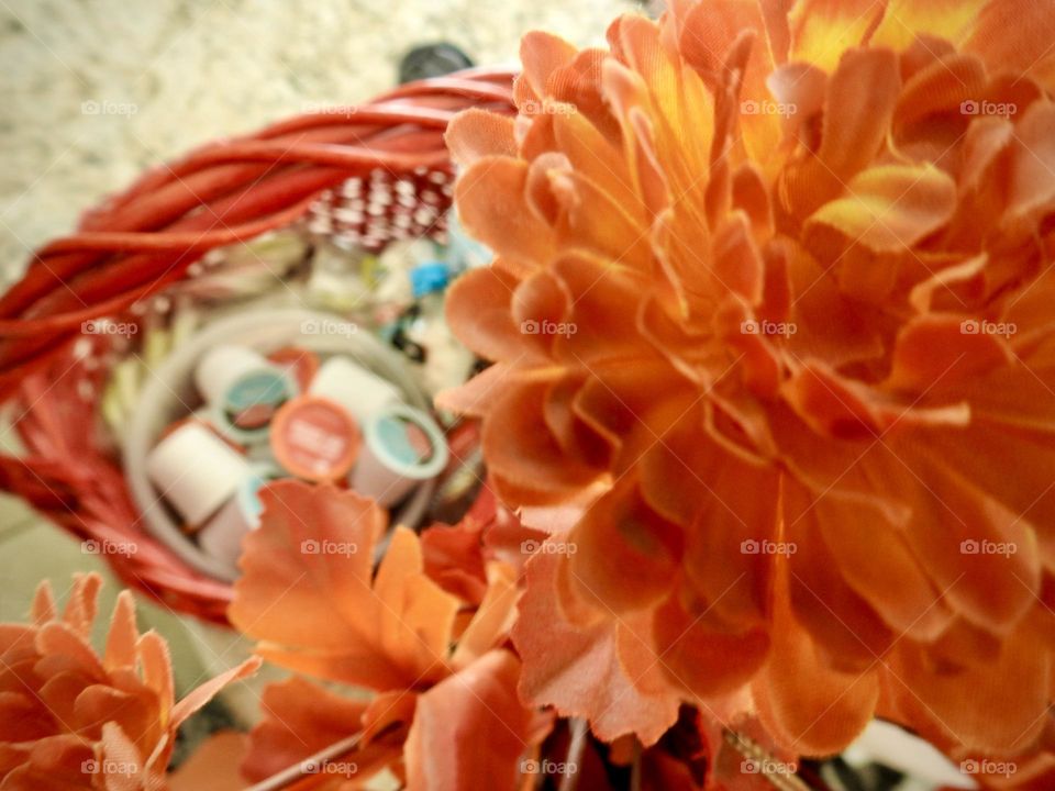 Orange yellow bouquet representing fall autumn in front of a woven dark red basket perfect for autumn fall days to warm up with hot chocolate keurig cups.