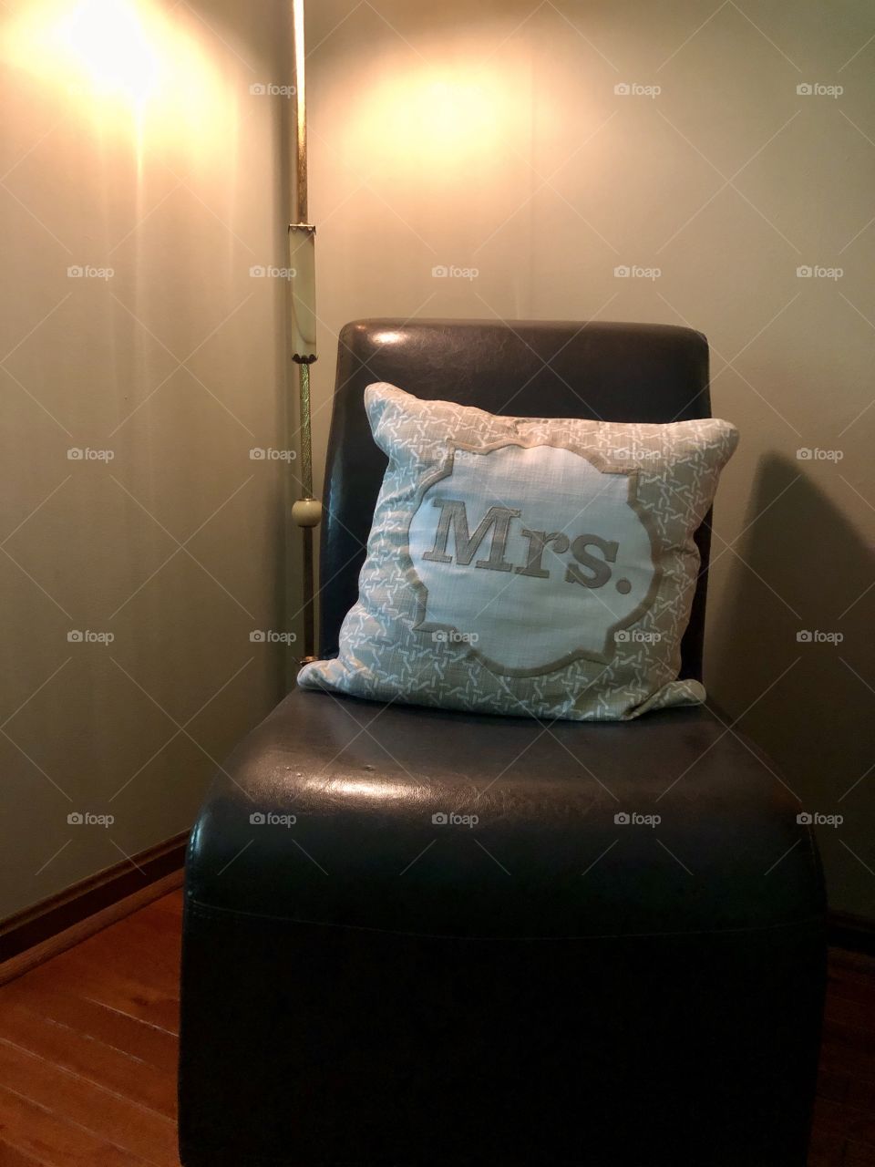 Corner of interior home with chair and pillow and soft lamp light 