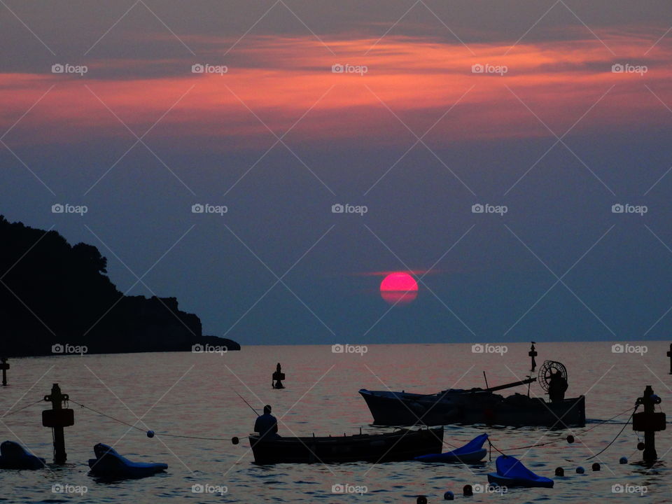 Fishermen reeling in the last rays of the day along the Sorrento Bay in Italy 