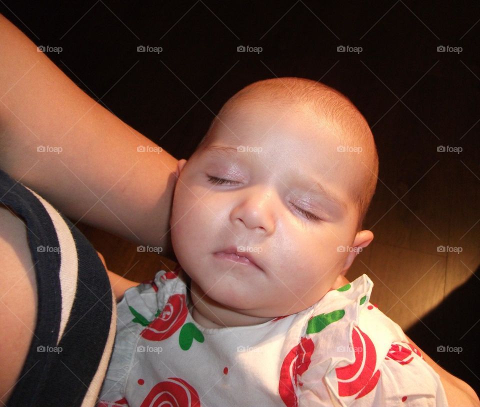 Baby girl sleeping in her mother's arms