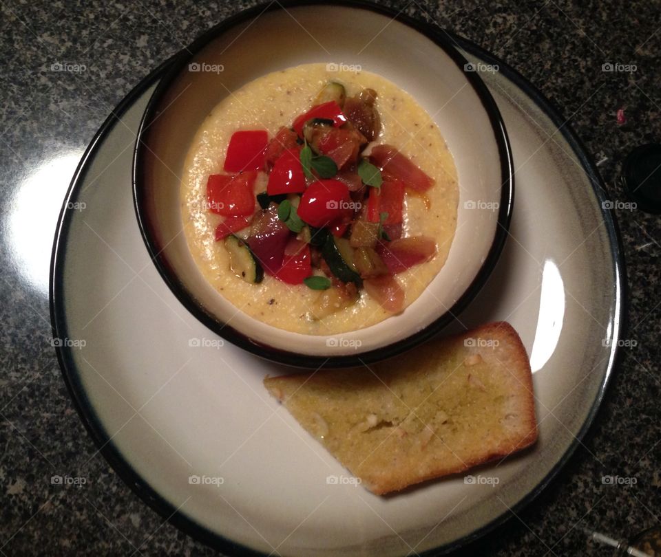 Homemade ratatouille over polenta served with a garlic baguette 
