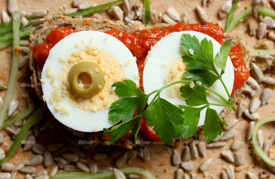 A sandwich with egg slices and tomato sauce