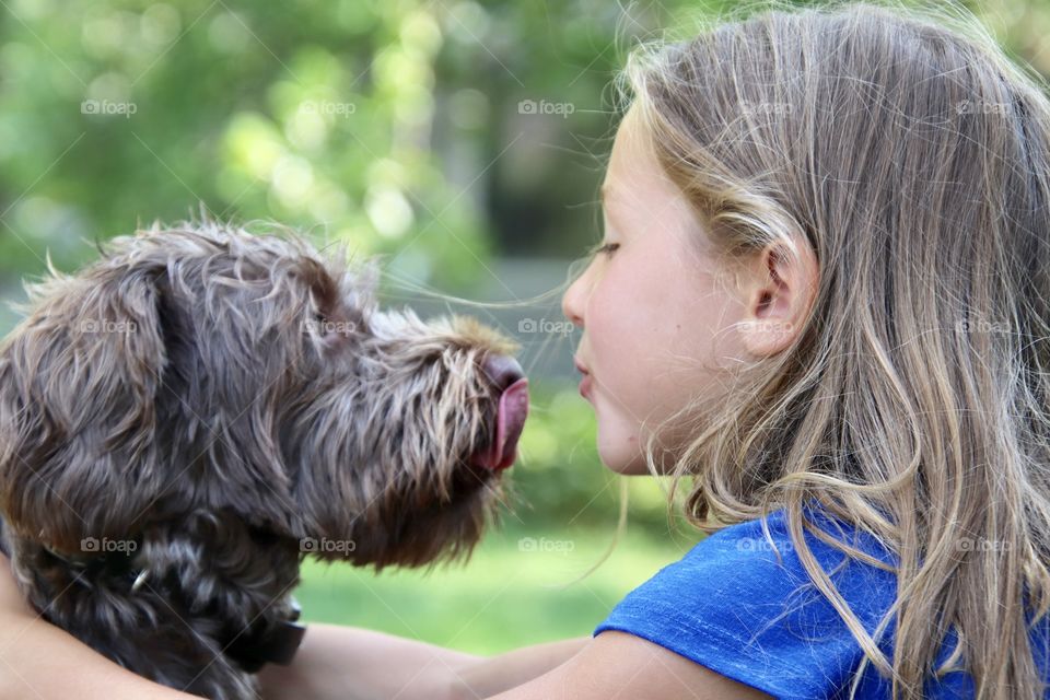Dog kisses and little girl