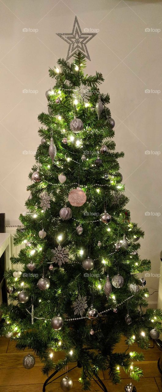 pink and silver illuminated Christmas tree. lit tree with colour