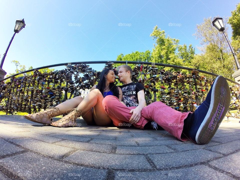 Couple sitting in front of railing with padlocks