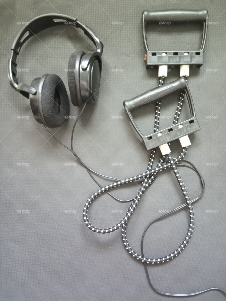 Interesting black and grey arrangement of earphones and sport equipment, depicting love for music and sport.