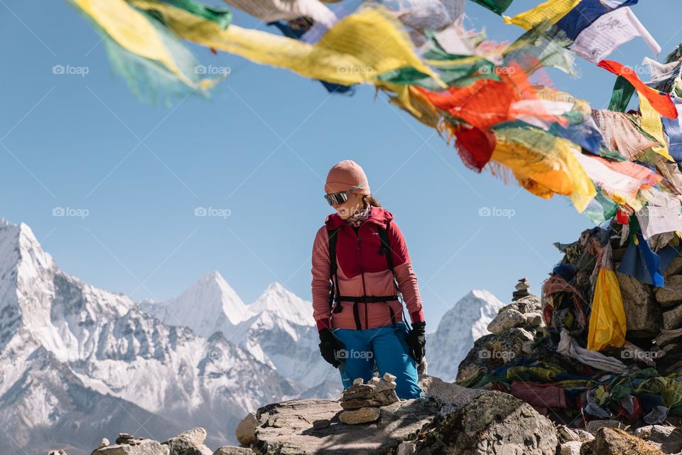 Woman colorfully dressed, posing in front of a mountain background, while hiking in Nepal- Himalayas.