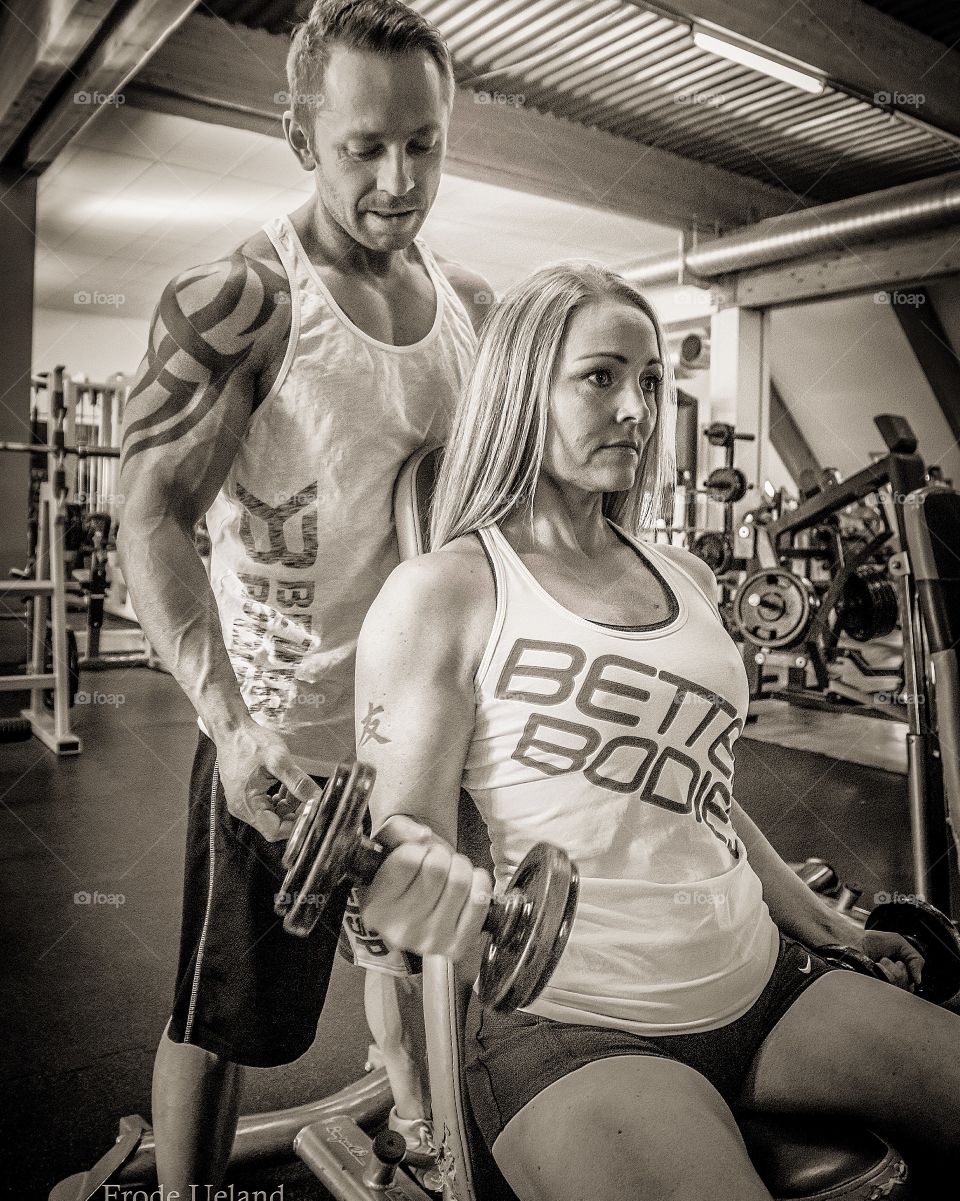 Personal trainer helping woman in gym