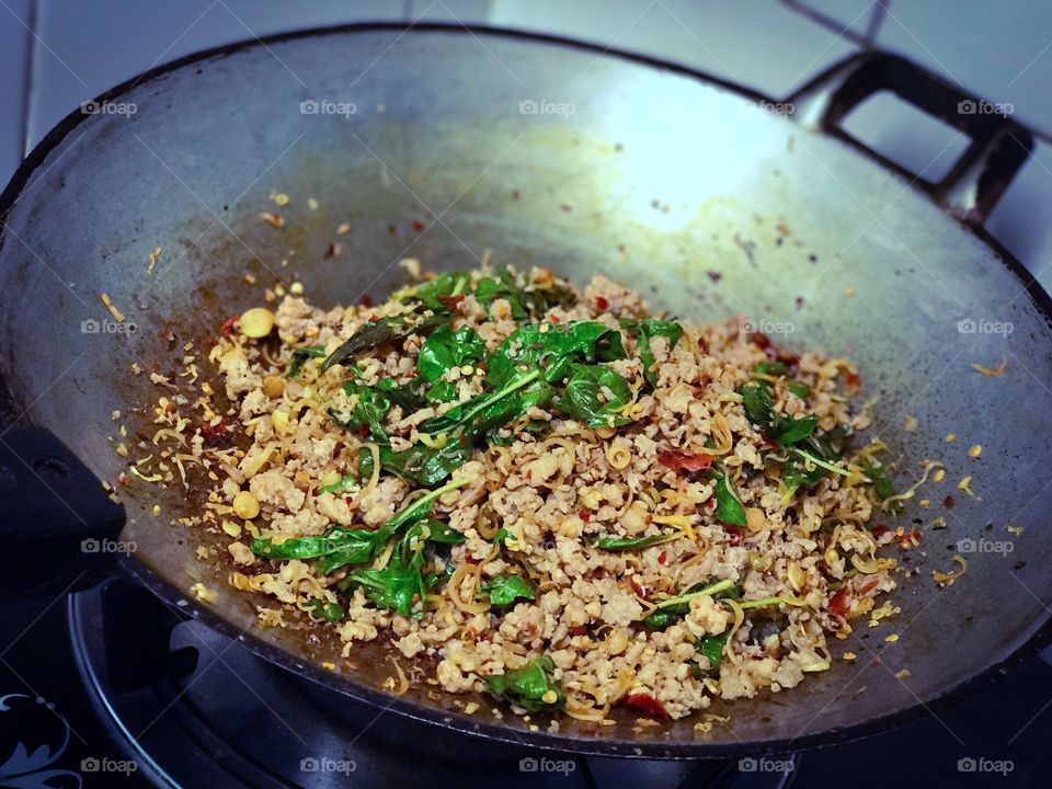Stir-fried minced pork with basil leaves in hot pan